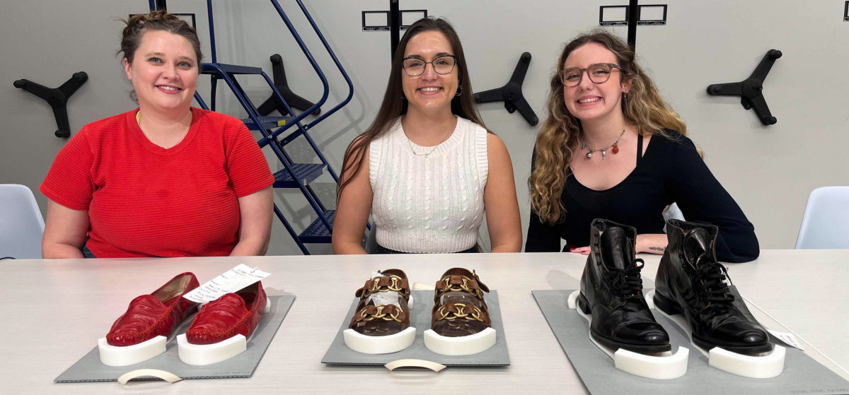 Ailie Pankonien, Katherine Santos and McKenna Applewhite seated in front of a shoe display